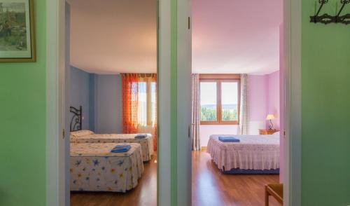 a bedroom with two beds and a window at Casas Rurales La Niña A in Villacorza