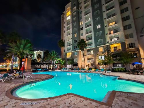 a swimming pool in a hotel at night at Modern Flat 4 Minutes from Universal – The Point Orlando in Orlando
