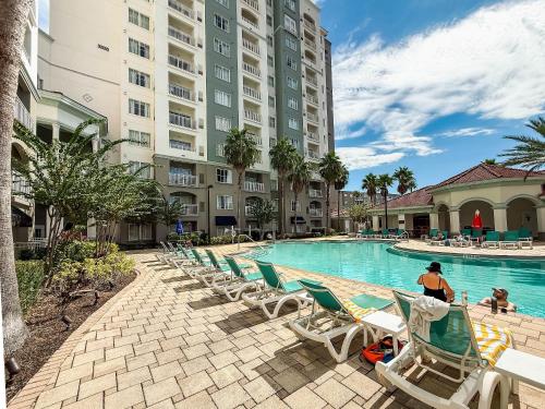 a hotel swimming pool with lounge chairs and a large building at Modern Flat 4 Minutes from Universal – The Point Orlando in Orlando
