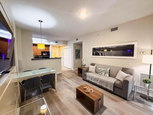 a living room with a couch and a table at Modern Flat 4 Minutes from Universal – The Point Orlando in Orlando