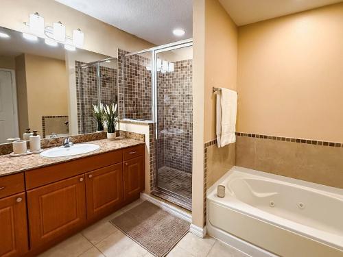 Modern Flat 4min from Universal Up to 4 Guests في أورلاندو: حمام مع حوض استحمام ومغسلة ودش