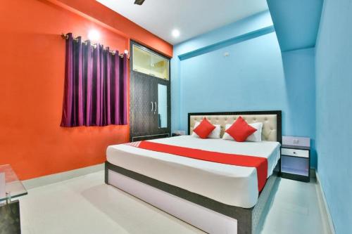 a bedroom with a bed with red and blue walls at Magadh Imperial Guest House in Patna