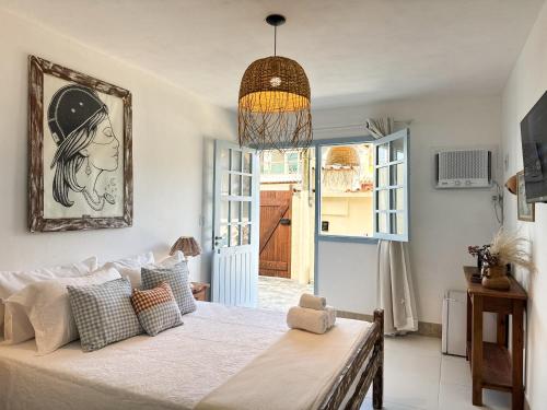 een slaapkamer met een bed en een hanglamp bij Vila Saruê in Búzios
