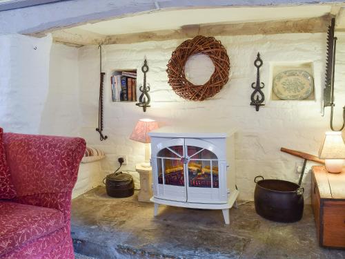 a living room with a fireplace and a red couch at Hathaway Hamlet in Stratford-upon-Avon