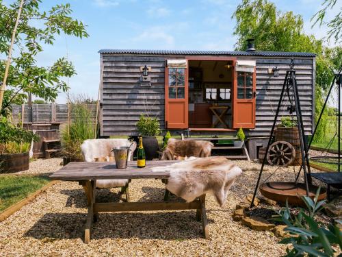 Una casita con dos perros sentados alrededor de una mesa. en Bonnie's Shepherd Hut - Uk50228, en Nottingham