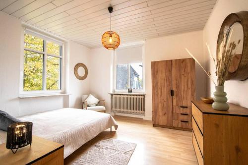 - une chambre avec un lit, un miroir et des fenêtres dans l'établissement Altbauwohnung in Mayen im Grünen, à Mayen