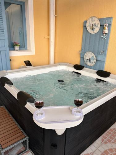 a hot tub with two glasses of wine in it at Villa Bonita Private Traditional house in Kamari