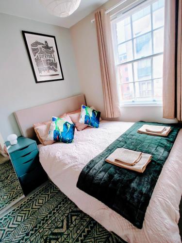 a bedroom with a large bed with a window at Victoria's Bright Georgian Apartment in Liverpool
