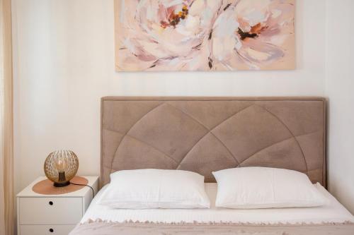 a bedroom with a bed and a painting on the wall at Apartman Kala-Two bedroom-Terrace in Sutivan