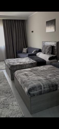 a room with three beds and a couch at غرفه فندقيه in Hurghada