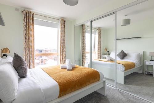 a bedroom with two beds and a large window at Stylish 2-Bed Penthouse Sleeps 6 Central Location in Belfast