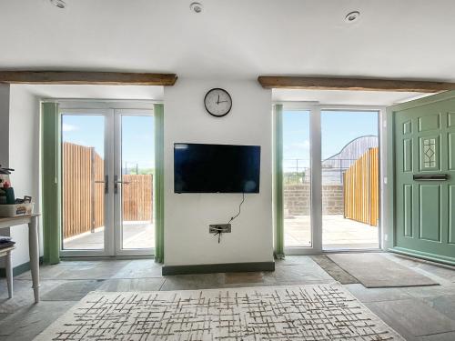 a living room with a tv on a wall with sliding doors at The Mill House Uk47418 in Curry Mallet