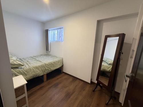 a small room with a mirror and a bed at Self-Contained Studio in Loganholme