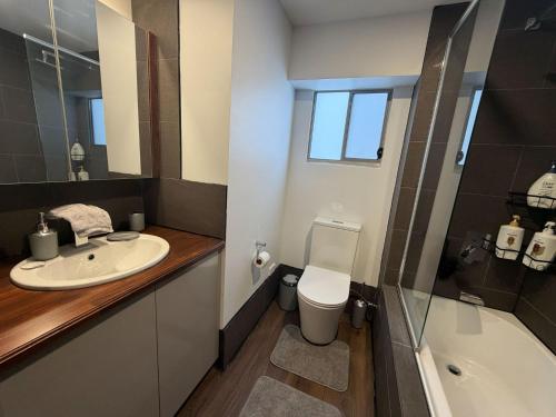 a bathroom with a sink and a toilet and a tub at Self-Contained Studio in Loganholme