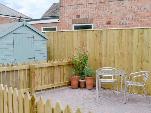 a wooden privacy fence with a table and chairs on a patio at Garden Cottage in Bridlington