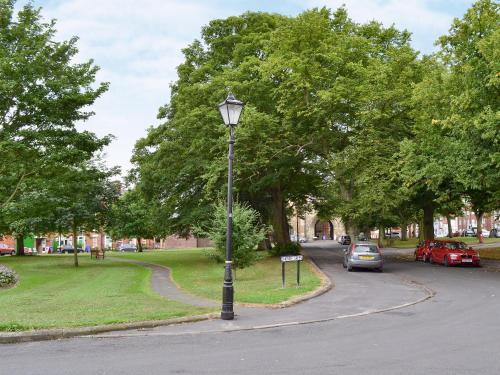 a street light with cars parked in a park at Garden Cottage in Bridlington