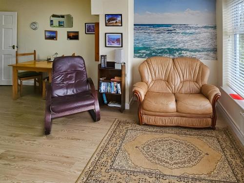 ein Wohnzimmer mit einem Stuhl und einem Tisch in der Unterkunft This 'N' That in Tintagel