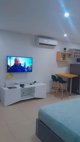 ein Wohnzimmer mit einem Flachbildfernseher an der Wand in der Unterkunft Uban Oasis in Accra
