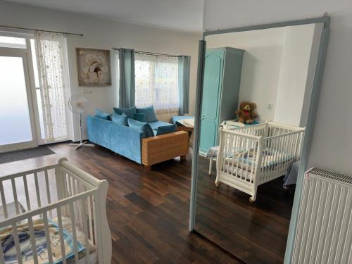 a living room with a blue couch and a crib at Cichy Zaułek 3a in Brodnica