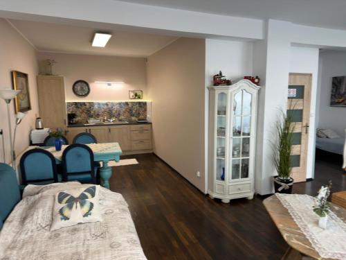 a living room with two beds and a table and a kitchen at Cichy Zaułek 3a in Brodnica
