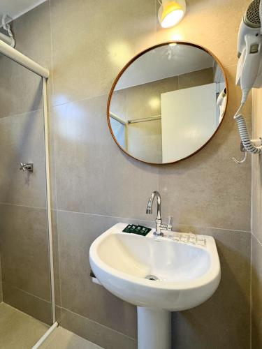 een badkamer met een wastafel en een spiegel bij Vila Saruê in Búzios