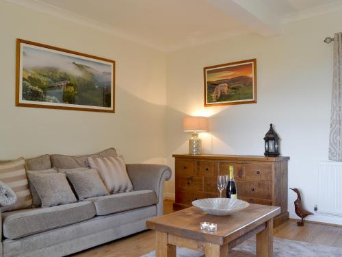 a living room with a couch and a table at Ling Farm Cottage in Holmewood