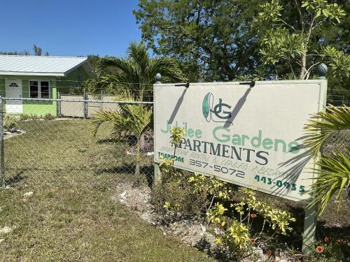 a sign in front of a yard with a house at Jubilee Gardens Freeport in Freeport