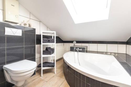 un bagno con una vasca bianca e un water di Stylish, cozy and natural apartment a Mendig