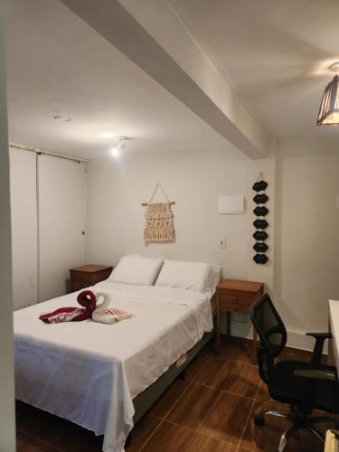 - une chambre avec un grand lit blanc et une chaise dans l'établissement Loft Vista Mar, à Itacaré