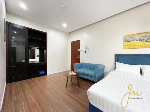 een hotelkamer met een bed en een blauwe stoel bij Phuong Hoang Hotel in Vung Tau