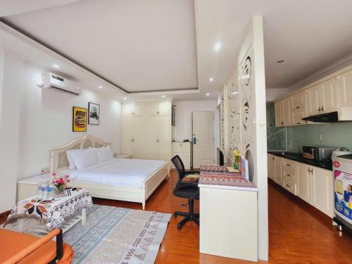 una camera da letto con un letto bianco e una cucina di Diamond Suite Apartment ad Ho Chi Minh