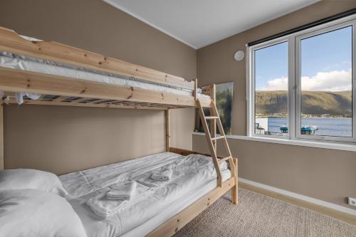 ein Schlafzimmer mit Etagenbett und Fenster in der Unterkunft Northstay - Tromsø Harbor Mountain View Apartment in Tromsø