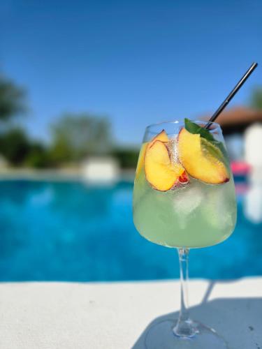 une boisson aux fruits dans un verre au bord d'une piscine dans l'établissement Αρχοντικό Παπανικολάου, à Lygariá