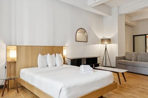 a hotel room with a bed and a couch at Placemakr Wall Street in New York