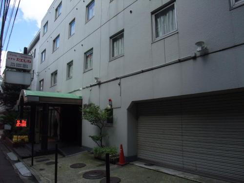 a large white building with a parking garage next to it at Hotel Tateshina in Tokyo