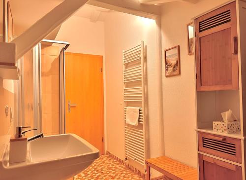 a bathroom with a tub and a shower and a sink at Gemütliche Fachwerkwohnung mit Hängematte, Elbnah 300m in Magdeburg