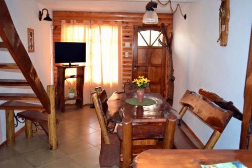a living room with a table and a television at Cabañas Playa del Sol in San Clemente del Tuyú