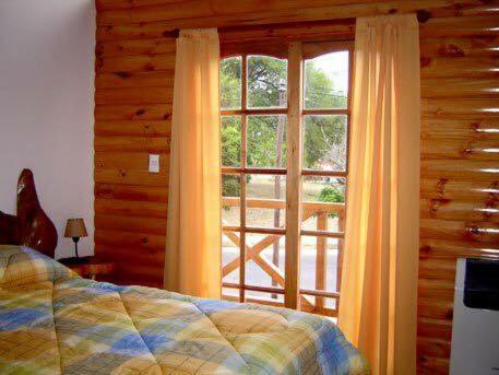 1 dormitorio con cama y ventana grande en Cabañas Playa del Sol en San Clemente del Tuyú