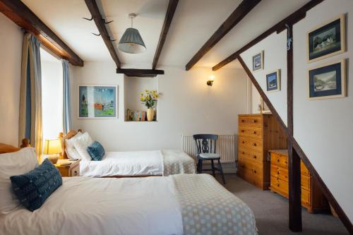 a bedroom with two beds and a dresser in a room at Charming Upper Solva Cottage by Beaches and Harbour in Solva