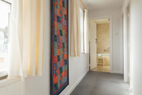 a hallway with a tapestry hanging on the wall at Charming Upper Solva Cottage by Beaches and Harbour in Solva