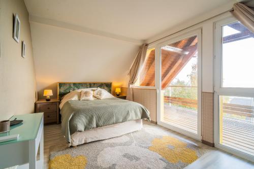 a bedroom with a bed and a large window at Castle view terrace - Swimming pool - Air conditioning in La Vancelle