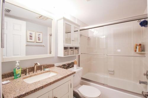a bathroom with a toilet and a sink and a shower at Tranquil condo minutes from Venice Beach - Beach Bungalow in Nokomis