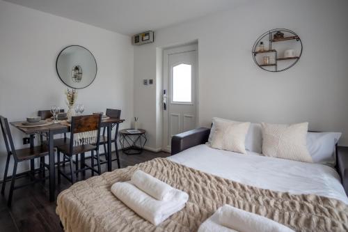 a bedroom with a bed and a table and a dining room at Comfortable Home Near Supermarket with Parking & Garden in Bullingham