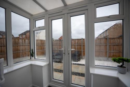 a room with windows and a view of a building at Comfortable Home Near Supermarket with Parking & Garden in Bullingham
