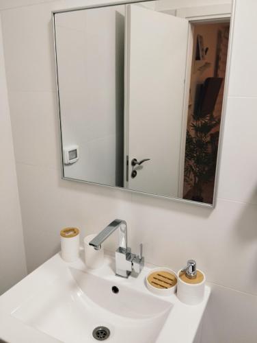 a bathroom with a white sink and a mirror at Dekel Dom Baharava in Beʼer Ora