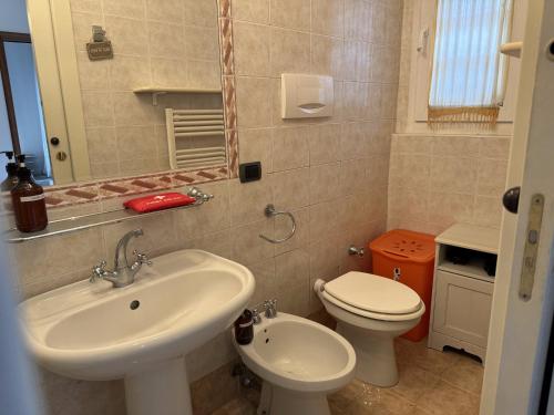 a bathroom with a sink and a toilet and a mirror at Luca's Home - a due passi dal Centro Storico in Como