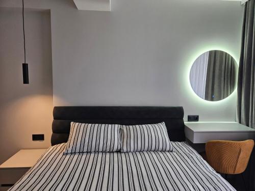 a bedroom with a bed and a round mirror at ZEN home in Chişinău
