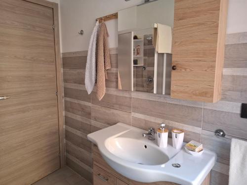 a bathroom with a white sink and a mirror at La Casa Del Borgo in Torre Pellice