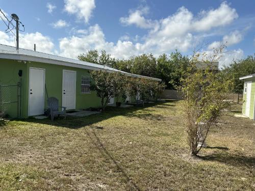 a green house with a chair in a yard at Jubilee Gardens Freeport in Freeport