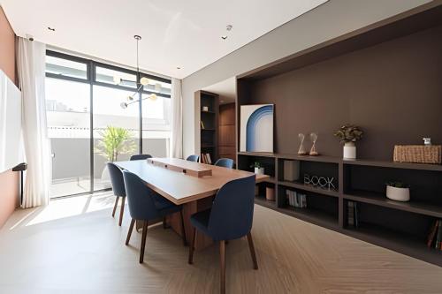 a dining room with a wooden table and blue chairs at Studio Elegante Próxi a USP By Marcolini in Sao Paulo